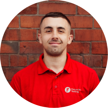 Photo of Tom smiling and wearing the red Focus On Testing uniform 