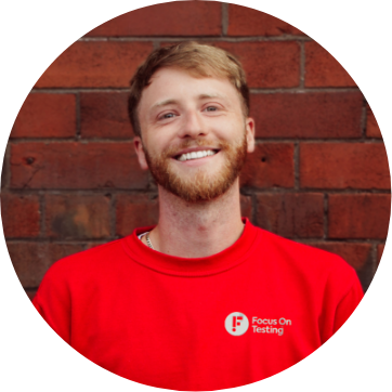 Photo of Adam smiling and wearing the red Focus On Testing uniform 