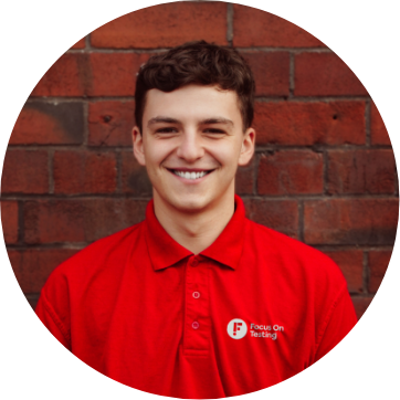 Photo of Coburn smiling and wearing the red Focus On Testing uniform 