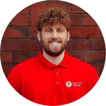 Photo of Gareth smiling and wearing the red Focus On Testing uniform 