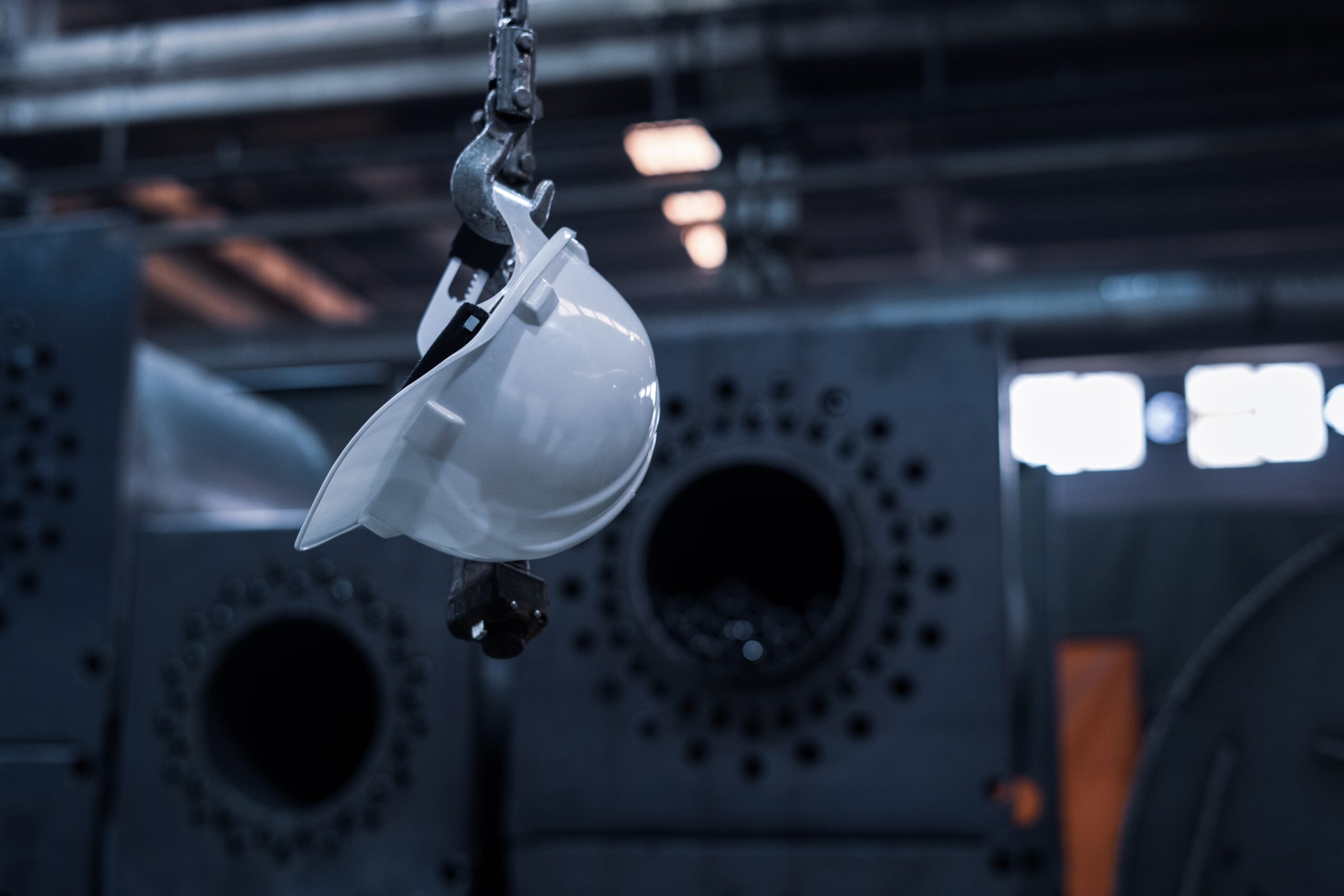 workplace safety: a hard hat hanging from pipework